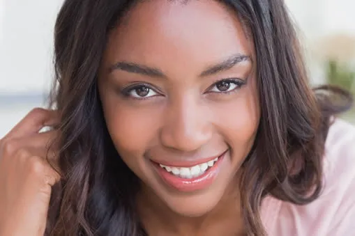 Young woman with beautiful smile after porcelain veneers at B Well Dental Studio